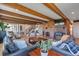 Open living space with wood-beamed ceilings, a fireplace, access to the staircase and plenty of seating at 1549 Hillside Cir, Sedalia, CO 80135