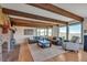 Spacious living room featuring wood-beamed ceilings, brick fireplace, and large windows with scenic views at 1549 Hillside Cir, Sedalia, CO 80135
