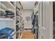 Spacious walk-in closet with custom shelving, hardwood floors, and a dedicated bench for shoe storage at 1549 Hillside Cir, Sedalia, CO 80135