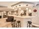 Finished basement with a bar, featuring granite counters, seating, and open access to living room at 18963 E Long Ave, Centennial, CO 80016