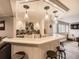 Basement bar with hanging pendant lights, marble countertops, and plentiful liquor storage at 18963 E Long Ave, Centennial, CO 80016