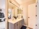 Well-lit bathroom features double sinks, gray cabinets, and a view into the bedroom at 18963 E Long Ave, Centennial, CO 80016