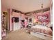 Cute pink bedroom for children, with shelving, desk, and tv at 18963 E Long Ave, Centennial, CO 80016
