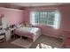 Bright bedroom featuring a large window, plush rug and bed, with white furniture and pink walls at 18963 E Long Ave, Centennial, CO 80016