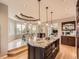 Kitchen with large island, wood cabinets, and dining area featuring large windows and a unique ceiling at 18963 E Long Ave, Centennial, CO 80016