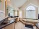 Bright bathroom features a vaulted ceiling, large window and tub with tile surround at 18963 E Long Ave, Centennial, CO 80016