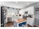 Modern kitchen with white cabinets, stainless steel appliances and an island with seating at 4715 Crestone Peak St, Brighton, CO 80601