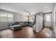 Living room with sectional sofa, hardwood floors, and entryway at 4715 Crestone Peak St, Brighton, CO 80601