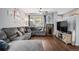 Living room with sectional sofa, hardwood floors, and fish tank at 4715 Crestone Peak St, Brighton, CO 80601