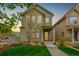 Charming two-story home featuring a well-maintained lawn, walkway, and vibrant yellow door at 1754 W 66Th Ave, Denver, CO 80221