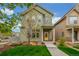 Charming home with a well-manicured lawn, landscaped yard, and a bright yellow door at 1754 W 66Th Ave, Denver, CO 80221