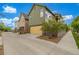 Green garage with bright yellow door and a driveway at 1754 W 66Th Ave, Denver, CO 80221