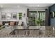 Close-up of a kitchen sink with granite countertops looking out to the living room and backyard at 1754 W 66Th Ave, Denver, CO 80221