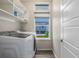 Well-organized laundry room with washer, dryer, storage shelves and window at 1754 W 66Th Ave, Denver, CO 80221