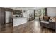 Open floor plan with modern kitchen flowing into a cozy living area with a view at 1754 W 66Th Ave, Denver, CO 80221