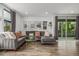 Stylish living room with a large sectional sofa, neutral tones, and sliding door access at 1754 W 66Th Ave, Denver, CO 80221
