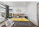 Well-lit main bedroom featuring a large window, decorative artwork, and hardwood-style flooring at 1754 W 66Th Ave, Denver, CO 80221