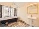 Bathroom featuring a clawfoot tub with shower, pedestal sink, and decorative tile, with ample natural light at 826 Maxwell Ave, Boulder, CO 80304