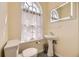 Bright bathroom featuring a pedestal sink, and modern toilet, with a charming arched window at 826 Maxwell Ave, Boulder, CO 80304
