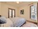 Comfortable bedroom with a quilt-covered bed, window providing natural light, and open doors to the bath at 826 Maxwell Ave, Boulder, CO 80304