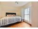 Bright bedroom featuring a comfortable bed with pink pillows, hardwood floors, and a window with shutters at 826 Maxwell Ave, Boulder, CO 80304