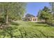 Sprawling backyard with mature trees, lush lawn, covered patio, and detached garage, perfect for entertaining at 1973 S Pitkin St, Aurora, CO 80013