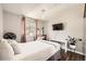 Sunlit bedroom includes a desk, TV, and window with curtains at 1973 S Pitkin St, Aurora, CO 80013