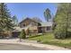 Charming two-story home featuring stone accents, a well-manicured lawn, and mature trees at 1973 S Pitkin St, Aurora, CO 80013