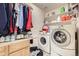 Functional laundry room with side-by-side washer and dryer, shelving, and countertop space at 1973 S Pitkin St, Aurora, CO 80013
