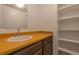 Bathroom with white sink and yellow counter alongside shelving unit in a neutral setting at 14823 E Colgate Dr, Aurora, CO 80014