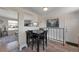 An open-concept dining area featuring a black table and chair set, bright lighting, and wood flooring at 14823 E Colgate Dr, Aurora, CO 80014