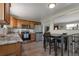 Well-lit kitchen featuring wood cabinets, stainless steel appliances, granite countertops, and wood flooring at 14823 E Colgate Dr, Aurora, CO 80014