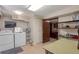 Functional laundry room with modern washer, dryer, and convenient shelving at 14823 E Colgate Dr, Aurora, CO 80014