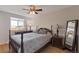 Comfortable main bedroom featuring a classic bed frame, a ceiling fan, and natural light at 14823 E Colgate Dr, Aurora, CO 80014