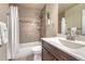 Bathroom with shower-tub combo, decorative tile surround, white vanity, and gray flooring at 22021 Pebble Brook Ln, Parker, CO 80138