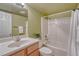 Bathroom features a shower-tub combo, single sink vanity, and neutral green walls at 22021 Pebble Brook Ln, Parker, CO 80138