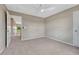 This bedroom features neutral carpet and walls, a ceiling fan, and an entrance to the upper landing at 22021 Pebble Brook Ln, Parker, CO 80138