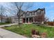 Beautifully landscaped front yard with mature trees, blooming shrubs, and a well-maintained lawn accentuating a two-story home at 22021 Pebble Brook Ln, Parker, CO 80138