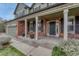 Welcoming front porch featuring brick columns, flower pots, and a stylish front door with sidelights at 22021 Pebble Brook Ln, Parker, CO 80138