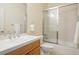 Bright bathroom featuring a white-tiled countertop, a framed mirror, and a shower with glass doors at 100 S University Blvd # 11, Denver, CO 80209