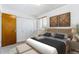 Well-lit bedroom with wood-look accents, a large bed, and an organized closet at 635 S Alton Way # 12C, Denver, CO 80247