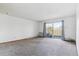 Spacious living room with a balcony, neutral carpeting and large glass doors at 635 S Alton Way # 12C, Denver, CO 80247