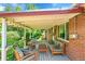 Charming covered back porch with comfortable seating, perfect for relaxing or entertaining guests at 5047 S Mabre Ct, Littleton, CO 80123