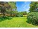 Manicured backyard featuring a lush green lawn, mature trees, and privacy landscaping at 5047 S Mabre Ct, Littleton, CO 80123