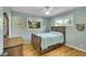 Tranquil bedroom with hardwood floors, a ceiling fan, and a large window offering serene views at 5047 S Mabre Ct, Littleton, CO 80123