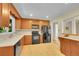 Well-lit kitchen features tile floors, wooden cabinets, black appliances, and white countertops at 5047 S Mabre Ct, Littleton, CO 80123