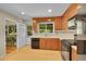 Bright and airy kitchen boasts tile flooring, wood cabinets, black appliances, and easy access to the backyard at 5047 S Mabre Ct, Littleton, CO 80123