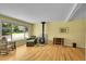 Bright living room featuring hardwood floors, a cozy wood-burning stove, and comfortable seating by the window at 5047 S Mabre Ct, Littleton, CO 80123