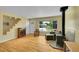 Inviting living room with hardwood floors, a wood-burning stove, and lots of natural light from the large window at 5047 S Mabre Ct, Littleton, CO 80123