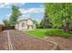Well-maintained backyard with green lawn, mature trees, privacy fence, and cozy patio with a fire pit feature at 5262 E Sandpiper Ave, Castle Rock, CO 80104